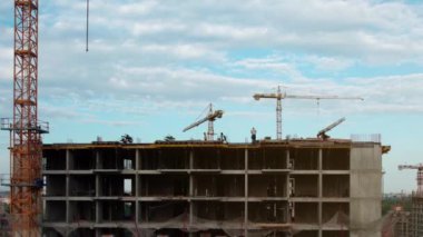 Hava manzarası, inşaat işçileri beton döken çok katlı modern bir binanın çatısında. Konut binası ya da ofis merkezi inşaatı. 4k görüntü