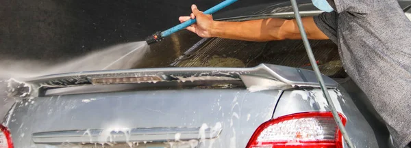 Mężczyzna Używający Węża Prania Myje Samochód Lokalnym Warsztacie Samochodowym — Zdjęcie stockowe
