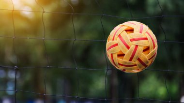 Rattan topu siyah ağın önünde.                              