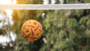 Rattan topu siyah ağın önünde.                              