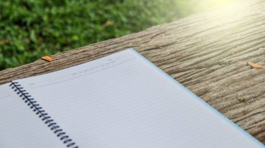 Çimlerin üzerinde kopyalama alanı olan beyaz defter kağıdı                              