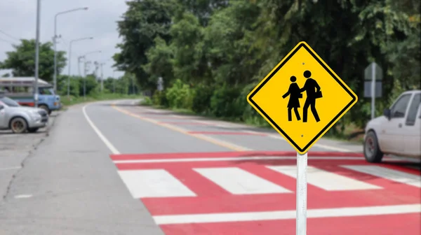 Yellow warn sign school zone to beware of children crossing the street on blur background