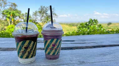 İçi kağıt etiketle sarılı plastik bardaklar. Kahve fincanının yazılı kahvesi ve grafikleriyle.