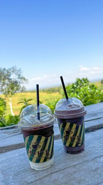 İçi kağıt etiketle sarılı plastik bardaklar. Kahve fincanının yazılı kahvesi ve grafikleriyle.