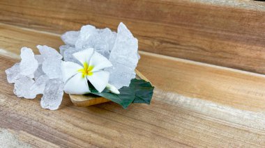 Crystal clear alum cubes or Potassium alum in small wooden dish chemical compound substance concept for beauty spa and underarm treatment industrial