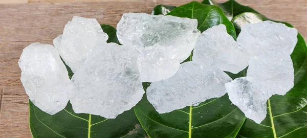 Crystal clear alum cubes or Potassium alum on green leaves chemical compound substance concept for beauty spa and underarm treatment industrial