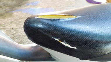 Eski siyah motosiklet koltuğunun üzerinde kesik izi olan kısmını kapat.