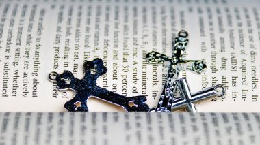Eski kitaptaki parlak metal haç tüm Hıristiyan İsa 'nın iyiliğini hatırlamak için.                               