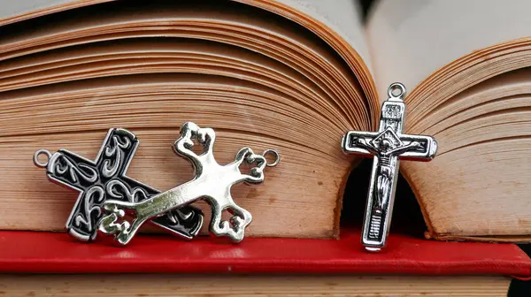 旧书上的新金属十字架 以回忆耶稣基督对所有基督徒的仁慈 — 图库照片