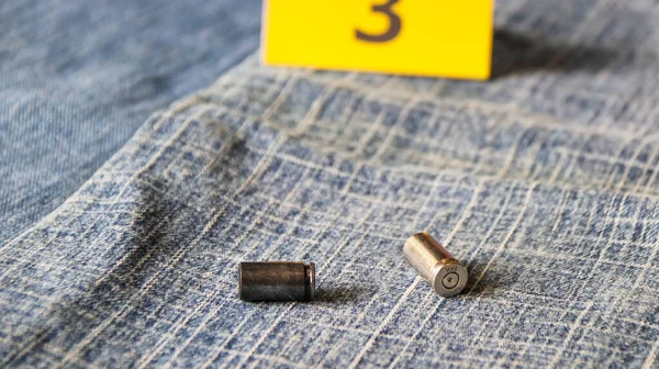 ブルージーンズのピストル弾と背景に3番目のディスプレイ 犯罪と捜査のための概念 ソフトフォーカス — ストック写真