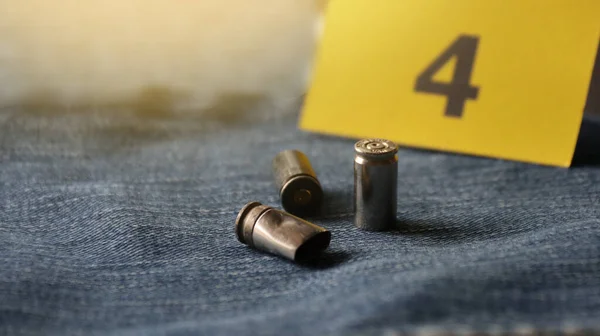 ブルージーンズのピストル弾と背景に4番のディスプレイ 犯罪と捜査のための概念 ソフトフォーカス — ストック写真