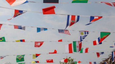 Mavi gökyüzü arka planında çeşitli ülke bayrakları                             