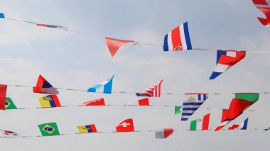 Mavi gökyüzü arka planında çeşitli ülke bayrakları                             