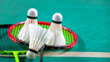 Beyaz badminton mekikleri ve badminton raketleri yeşil zemin badminton kortunda