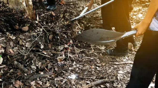 stock image Hands holding shovel to mix raw materials including dried leaves and dung to make bio fertilizer for growing plants