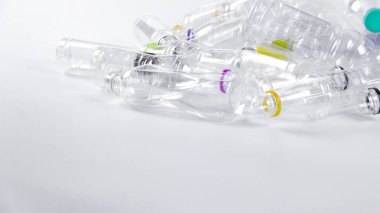 Beyaz bir yüzeyde geri dönüşümü bekleyen temiz plastik şişeler. Atıkların geri dönüşümünün, Dünya 'yı sevmenin ve doğal kaynakların korunmasının önemini vurgular.