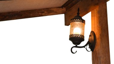 Antika bir lamba resmi toz ve örümcek ağlarıyla kaplı, eski antik evdeki eski koyu kahverengi ahşap bir duvara monte edilmiş.