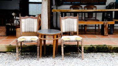 İki eski, ahşap sandalye ve kayalık masa rahat bir kahve dükkanının önünde, yoldan geçenleri oturmaya ve rahatlamanın tadını çıkarmaya davet ediyor..