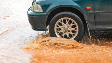 İçinden geçen bir aracın neden olduğu sel suları doğal afetin ham yoğunluğunu yakalıyor..