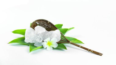 Yaprakların yanında duran temiz ve el değmemiş alüminyum küpleri, beyaz arka plana karşı dizilmiş, maddenin doğal saflığını ve geleneksel sunumunu sergiliyor..