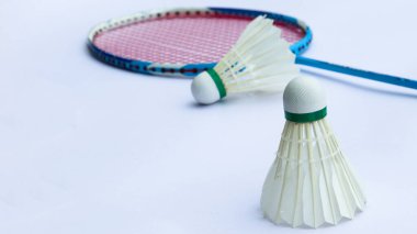 Beyaz arka planda raketleri olan Badminton mekikleri spor ve küresel rekabetin ruhunu, atletizmin özünü ve sporda mükemmelliği simgeliyor..