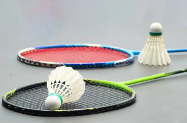 Karanlık arka planda raketleri olan Badminton mekikleri spor ve küresel rekabetin ruhunu, atletizmin özünü ve sporda mükemmelliği simgeliyor..