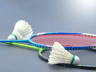 Beyaz badminton mekikleri ve arka planda badminton raketleri