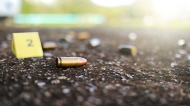 İki numaralı bulanık işaretli, kara zeminde yatan boş mermi kovanı. Cezai soruşturma kavramları