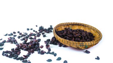 Koyu, kurutulmuş kahve çekirdeği kabukları bambu sepetinde ve beyaz arka planda, kabataslak dokusunu ve derin rengini vurguluyor, kahve üretimi ve işleme ile ilgili konular için uygun..