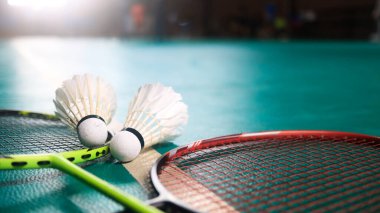 Beyaz badminton mekikleri ve badminton raketleri yeşil zemin badminton kortunda. Badminton yarışması ve aşıkları için kavram.