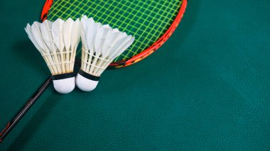 Beyaz badminton mekikleri ve badminton raketleri yeşil zemin badminton kortunda. Badminton yarışması ve aşıkları için kavram.