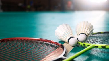 Beyaz badminton mekikleri ve badminton raketleri yeşil zemin badminton kortunda. Badminton yarışması ve aşıkları için kavram.