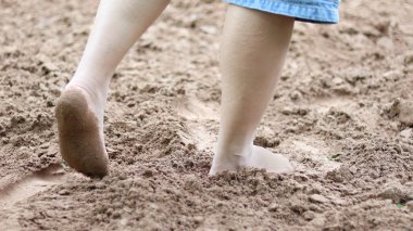 Çıplak ayakla kumlu zeminde yürümek, iyileşme fikrini sembolize etmek, hem fiziksel hem de zihinsel refahın temelleri ve doğayla olan bağlantısını desteklemek..