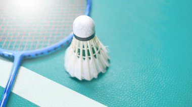 Beyaz badminton mekikleri ve badminton raketleri yeşil zemin badminton kortunda. Badminton yarışması ve aşıkları için kavram.