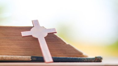 Koyu kırmızı bakır haç, Hristiyanlar arasında İsa 'nın sevgisini ve Hıristiyan öğretilerinin önemini yansıtan açık bir kitabın yayılmasını simgeliyor..