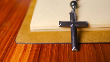 Hristiyanlar arasında İsa 'nın sevgisinin yayılmasını simgeleyen eski açık bir kitabın üzerindeki Dark Metal haçı Hıristiyanların bağlılığını ve Hıristiyan öğretilerinin önemini yansıtıyor..