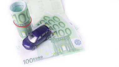 Araba, araba kredisi ve araba sigortası için tasarruf kavramı üzerine avro banknotları olan model araba.