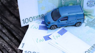 Arka planda avro banknotları olan model bir araba. Araba, araba kredisi ve araba sigortası için tasarruf planlama.