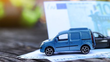 Arka planda avro banknotları olan model bir araba. Araba, araba kredisi ve araba sigortası için tasarruf planlama.