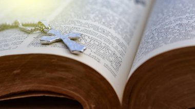 Eski açık bir kitaba dayanan parlak metal haç Hristiyanlar arasında İsa 'nın sevgisinin yayılmasını simgeliyor. İnanç bağlılığını ve Hıristiyan öğretilerinin önemini yansıtıyor..