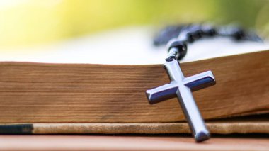 Hristiyanlar arasında İsa 'nın sevgisinin yayılmasını simgeleyen eski açık bir kitabın üzerindeki Dark Metal haçı Hıristiyanların bağlılığını ve Hıristiyan öğretilerinin önemini yansıtıyor..