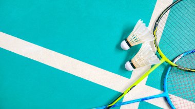 Beyaz badminton mekikleri ve badminton raketleri yeşil zemin badminton kortunda. Badminton yarışması ve aşıkları için kavram.