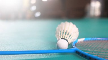 Beyaz badminton mekikleri ve badminton raketleri yeşil zemin badminton kortunda. Badminton yarışması ve aşıkları için kavram.