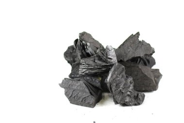 Temiz beyaz bir zemin üzerinde duran izole siyah kömür parçaları kaba dokusunu ve derin, zengin rengini sergiliyor. Izgara, sanat ve filtreleme için kullanılan kömür, enerji ve dönüşümü sembolize eder..