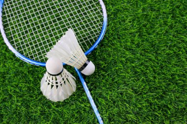 Beyaz mekiklerin horozları ve badminton raketleri suni çimlerin, açık hava sporlarının ve eğlencenin üzerinde dinleniyor..