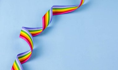Mavi pastel arka planda renkli gökkuşağı şeridi. Dünyanın dört bir yanındaki LGBT topluluklarına tezahürat yapma kavramı