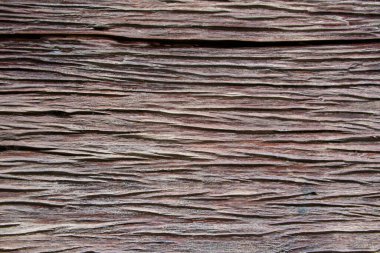 Koyu kahverengi ahşap bir yüzey birbirine yakın dizilmiş. Kırsal dekorasyon ve otantik ahşap tasarımlar için uygun organik desenleri vurgular.