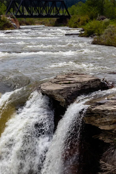 Water thunders over the falls in early spring. Lundbreck Falls PRA, Alberta, Canada