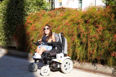 Tekerlekli sandalyedeki genç, engelli bir kadın şehirde gezintiyi azaltıyor. Eşitlik ve dayanışma kavramı