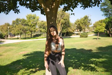 Genç, güzel, sarışın, mavi gözlü kadın ağaca yaslanıyor. Kadın farklı ifadeler kullanır, yorgun, üzgün, mutlu, neşeli, melankolik, nefret, keder. İfadeleri kavra.